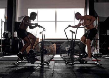 Two Fitness male using air bike cardio workout.