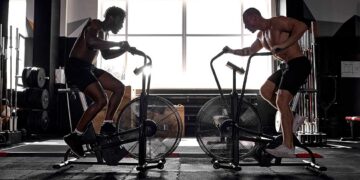 Two Fitness male using air bike cardio workout.